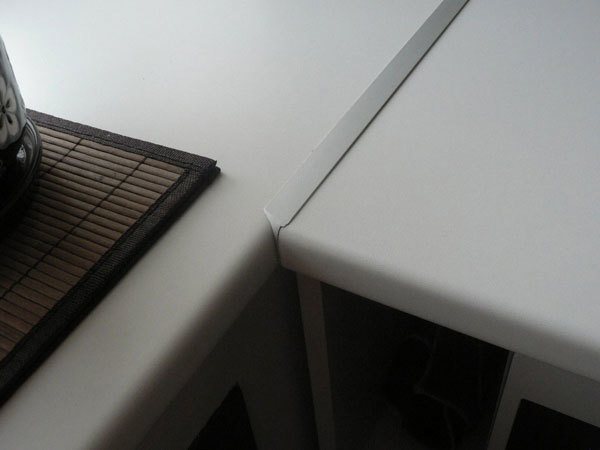 Masa tablasının iki yarısı arasındaki boşluk metal bir şeritle gizlenmiştir.