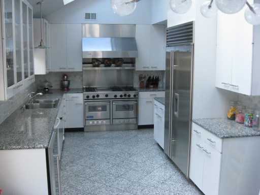 Fotoğraf klasik bir tasarım seçeneğini göstermektedir: gri bir mutfak ve beyaz mobilya.
