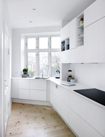 İç kısımdaki beyaz bir mutfak seti, ahşap elemanlar, siyah ev aletleri ile seyreltilebilir.