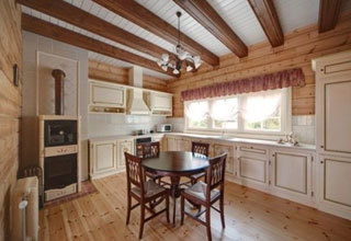Ahşap zeminler ve kirişli tavanlara sahip Provence tarzı mutfak.